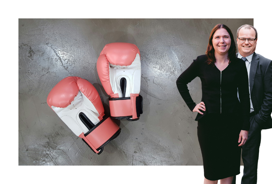 Pictured, Adam Wightman and Karlene Wightman standing smiling, behind them is an image of a pair of pink boxing gloves on the ground.